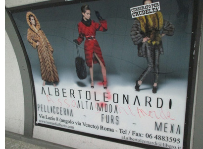 Photo shows an advertisement, a small banner saying 'censorato per crudelta' is covering the face of one of the 3 models wearing fur.